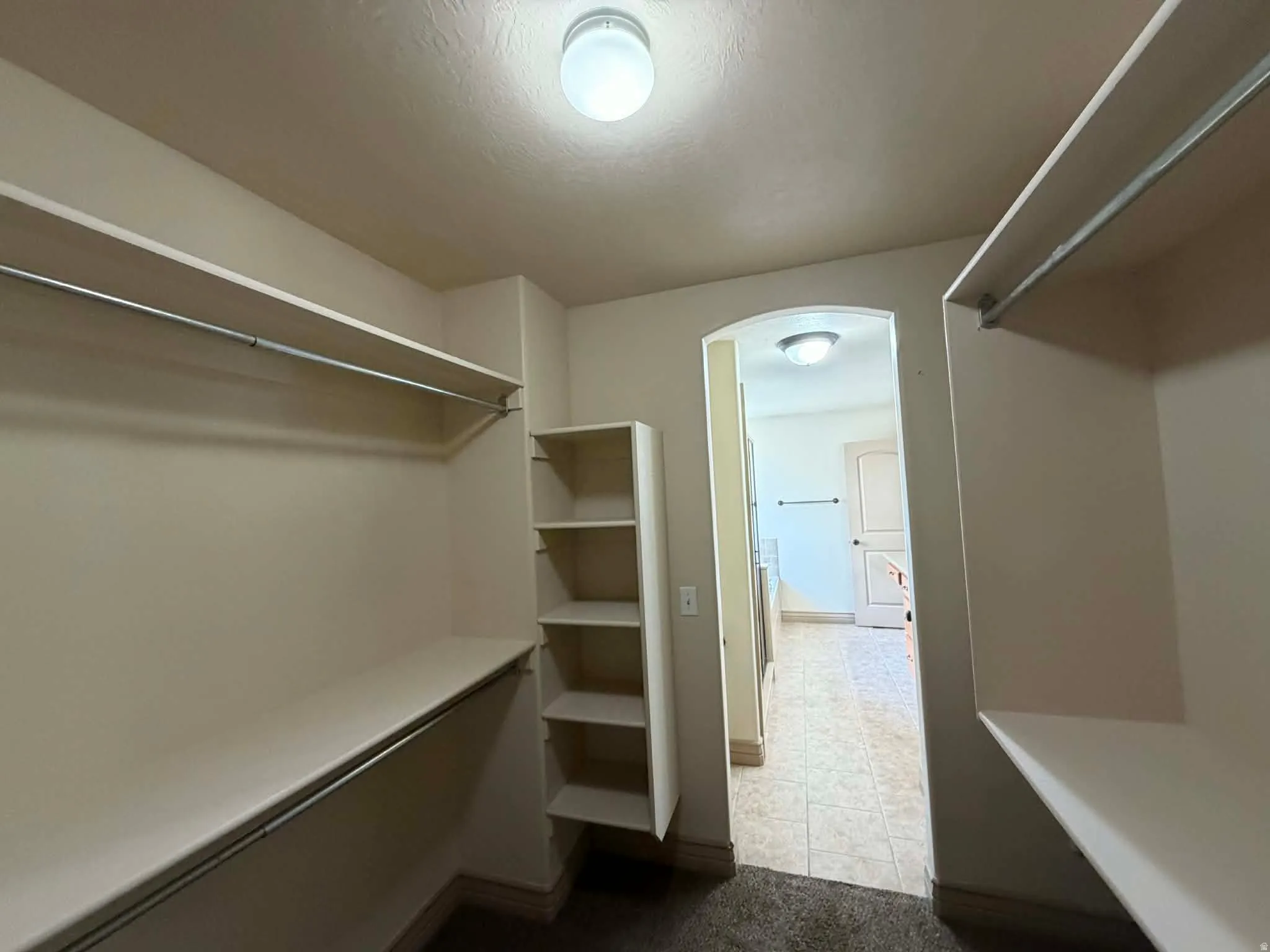 Walk in closet featuring arched walkways