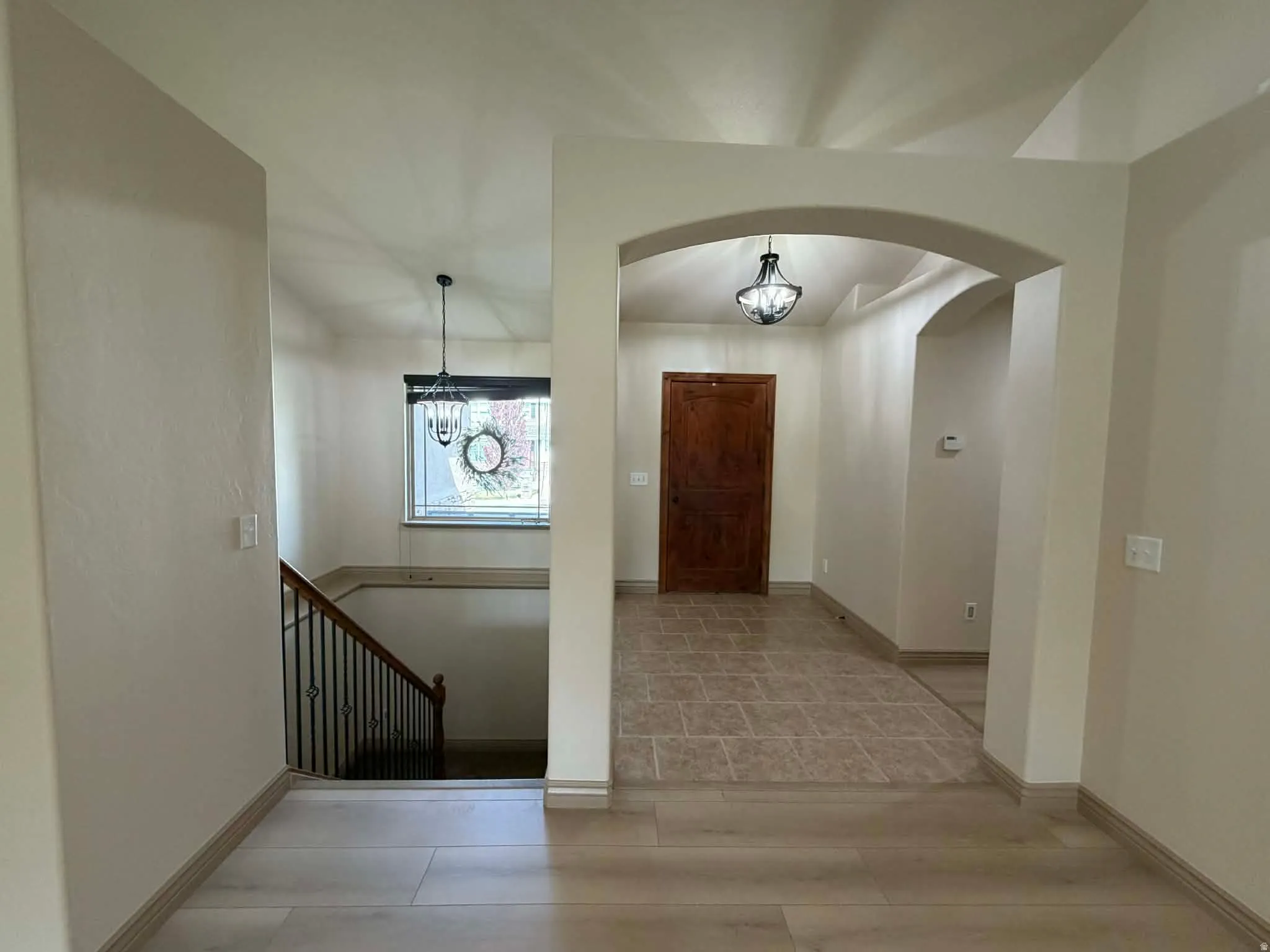 Foyer featuring hanging lights and arched walkways