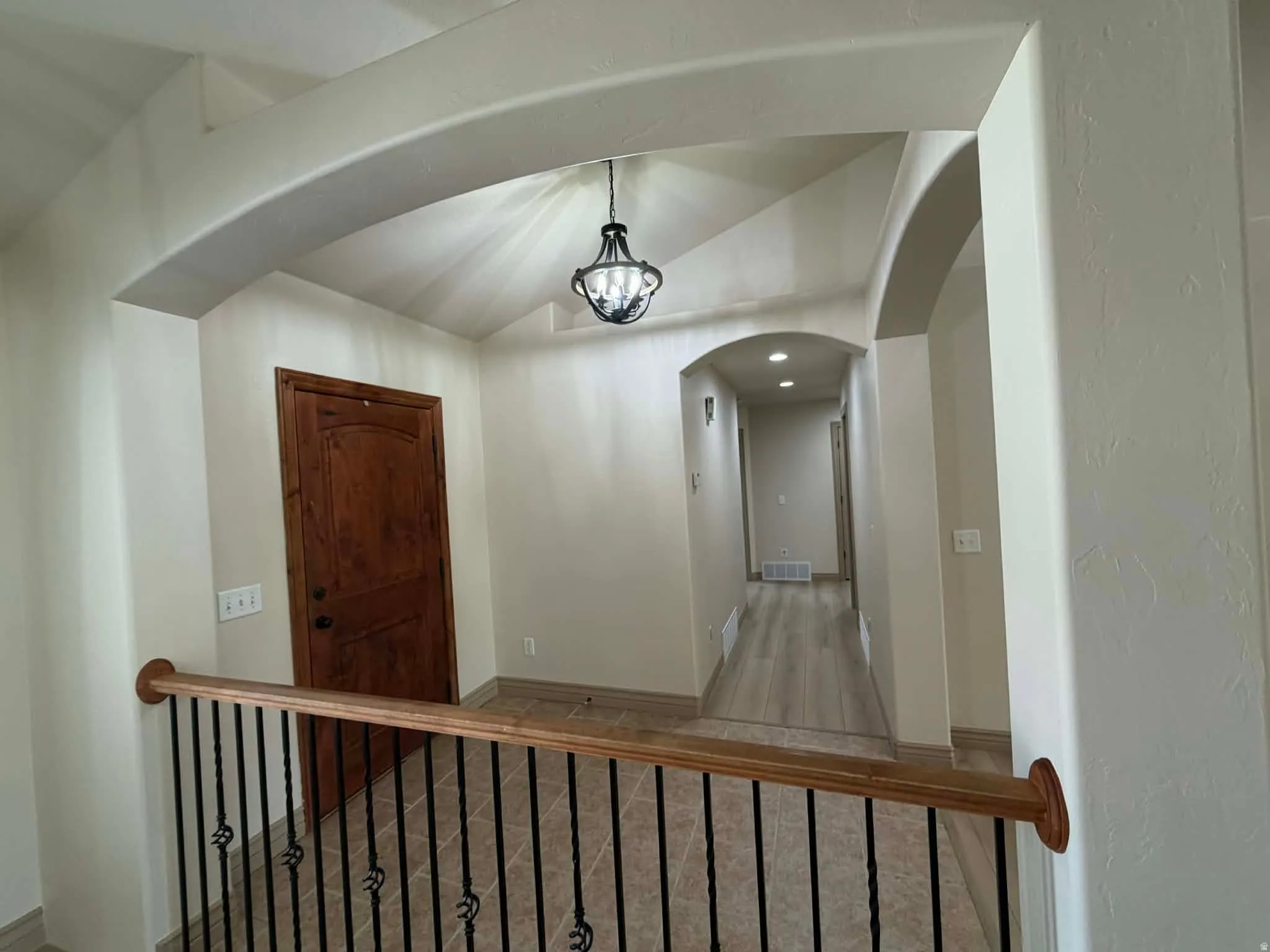 Hallway featuring vaulted ceiling and carpet