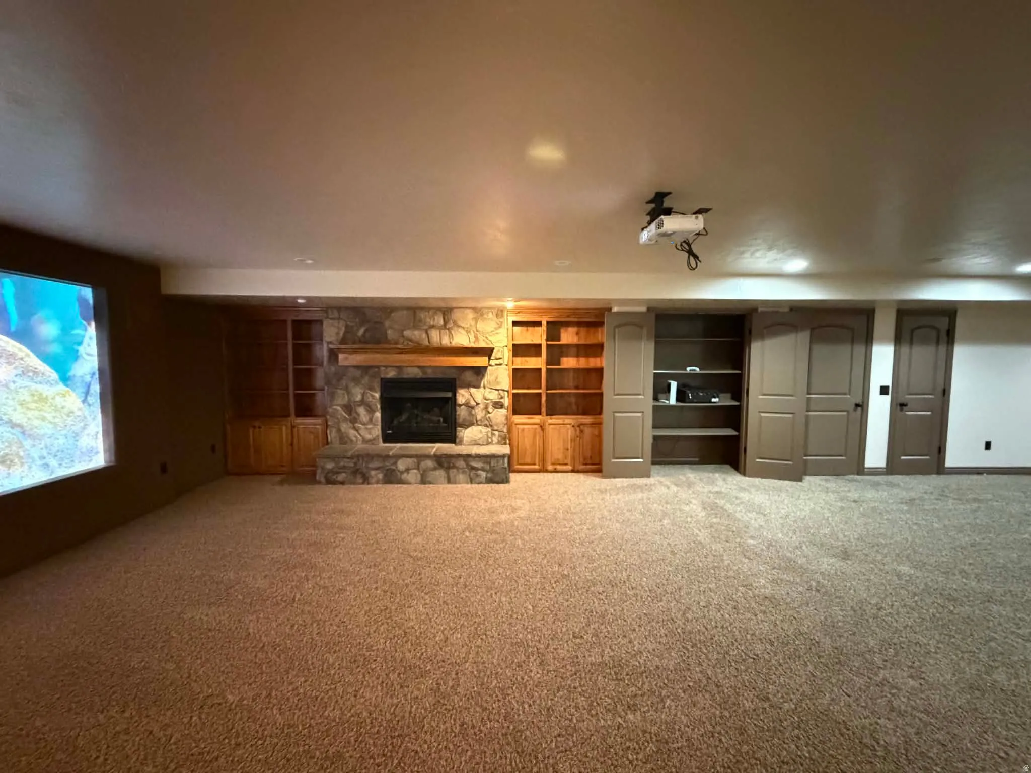 Unfurnished living room with carpet floors, a fireplace, and built in features