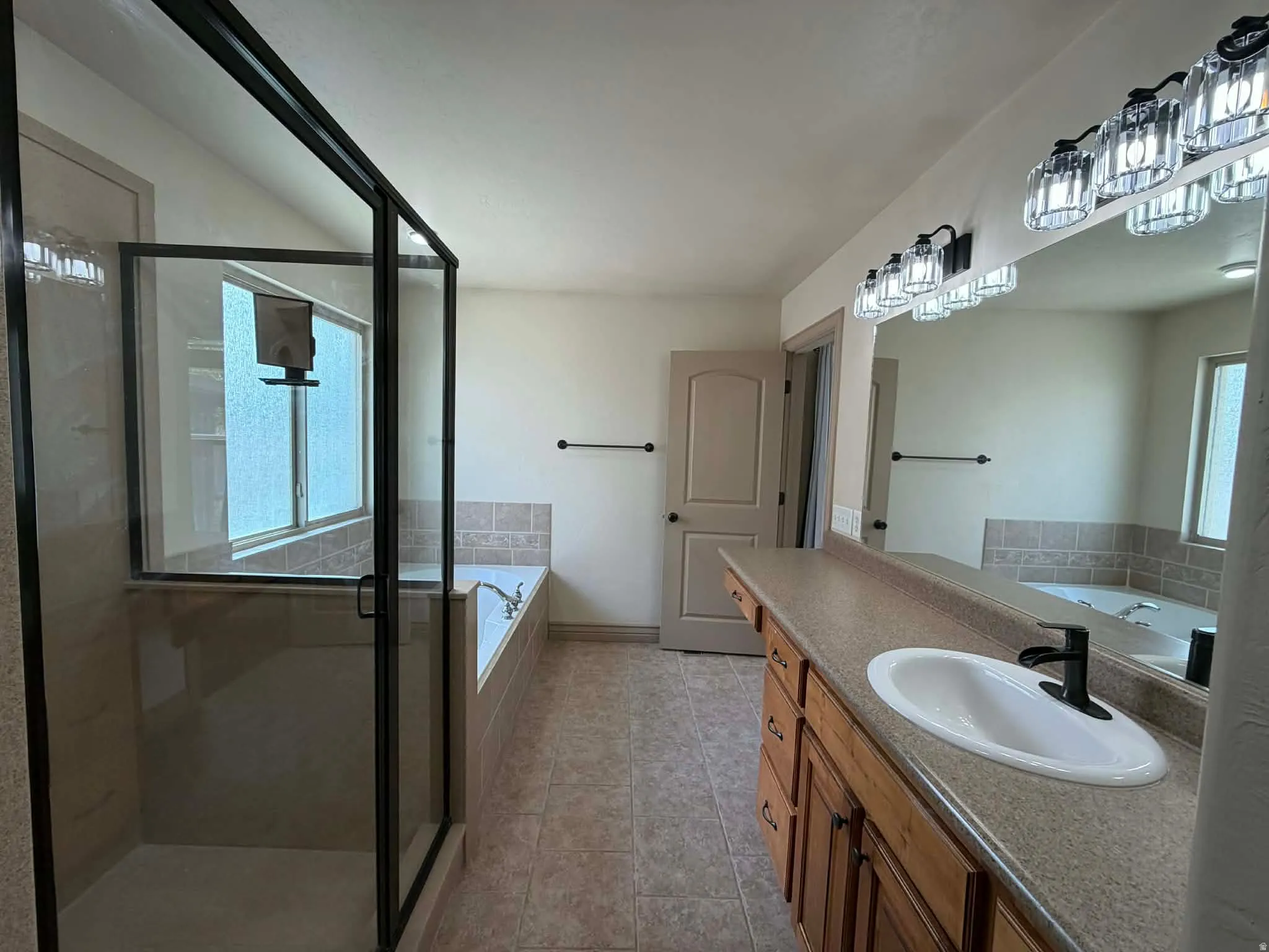 Bathroom with a garden tub, vanity, and a stall shower