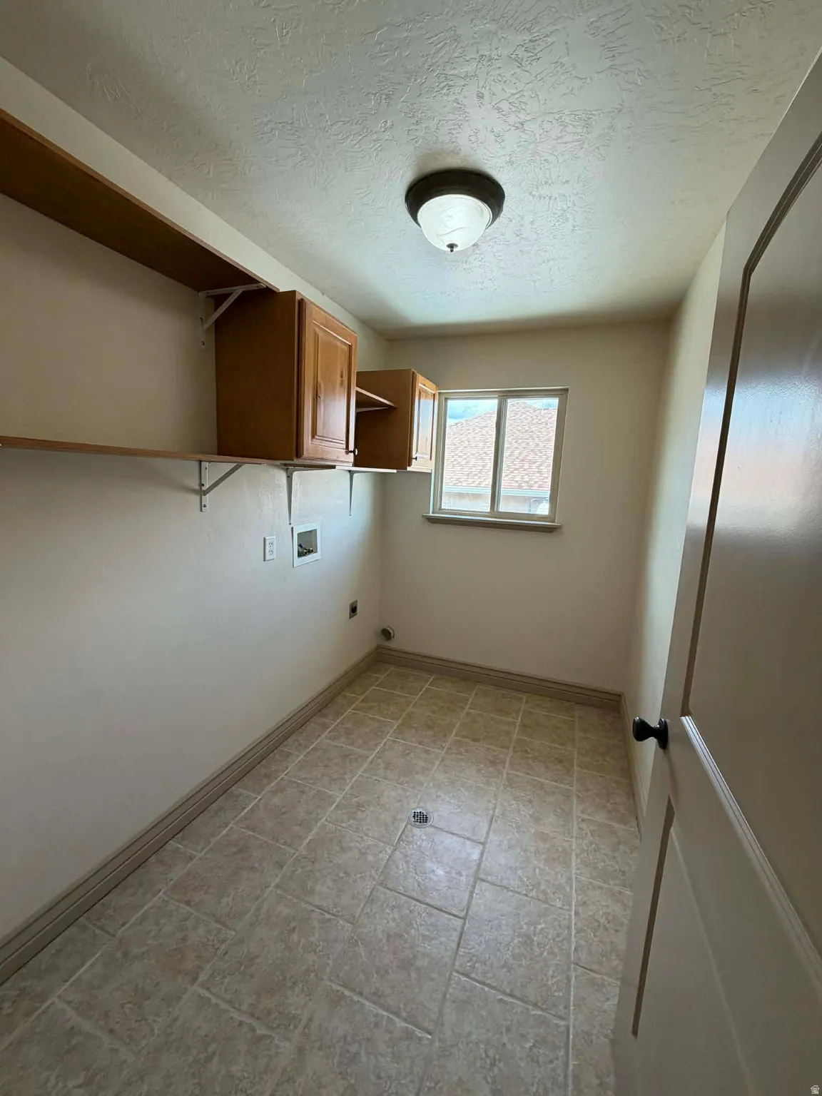 Laundry room with cabinet space, electric dryer hookup, washer hookup, and a textured ceiling