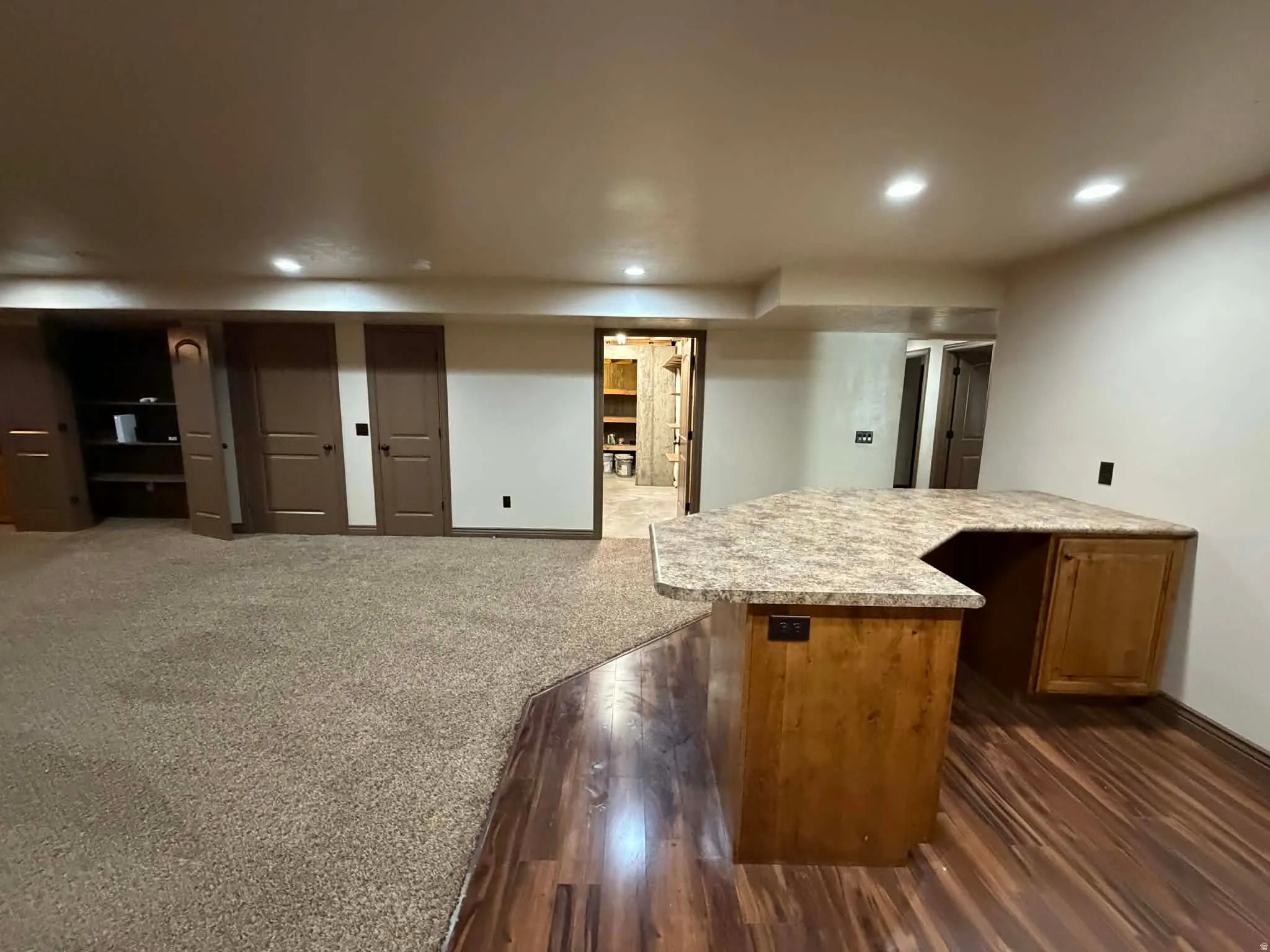 Bar featuring wood finish cabinetry, recessed lighting, dark colored carpet, and dark wood-style flooring