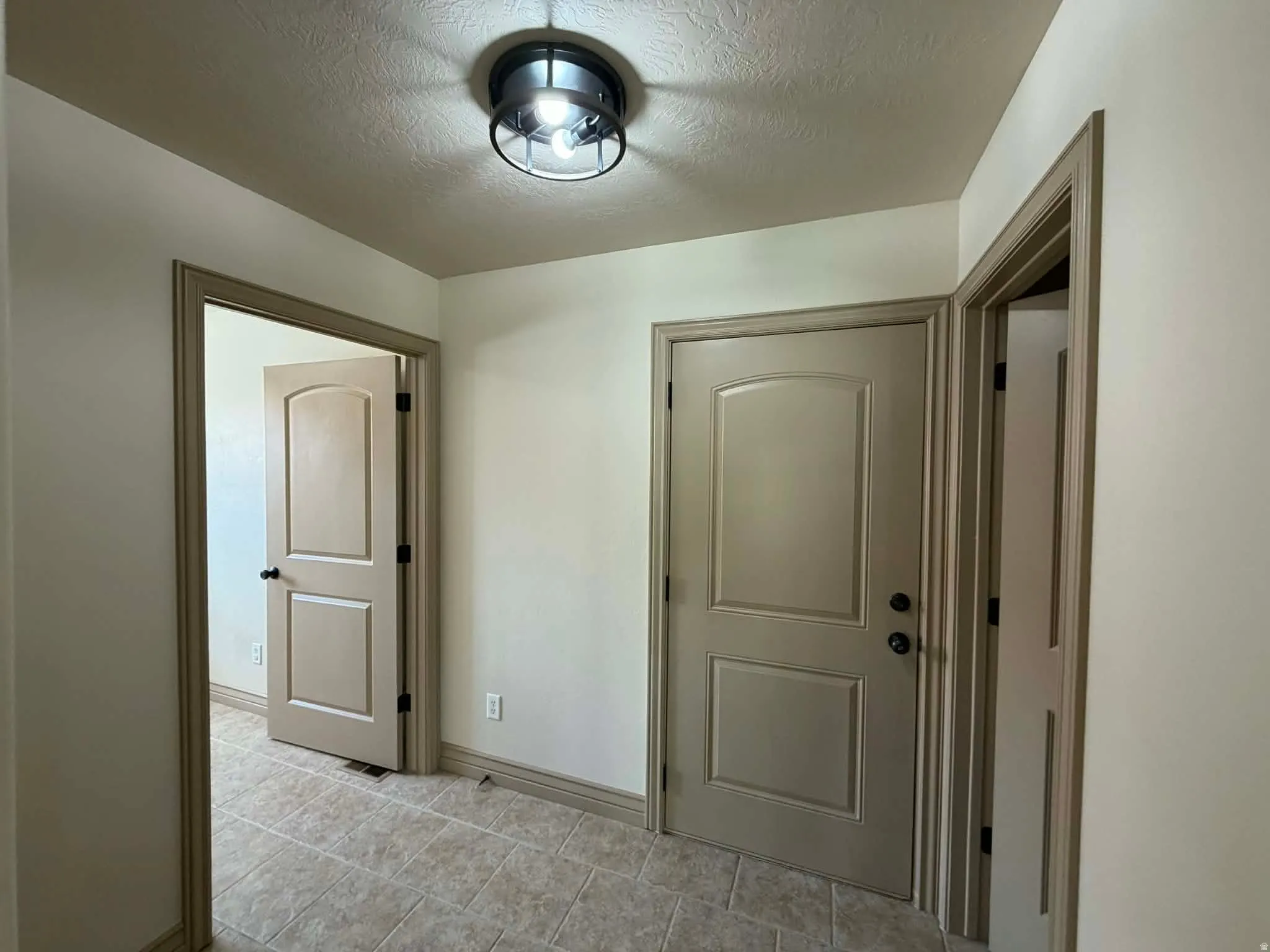 Foyer featuring a textured ceiling and baseboards