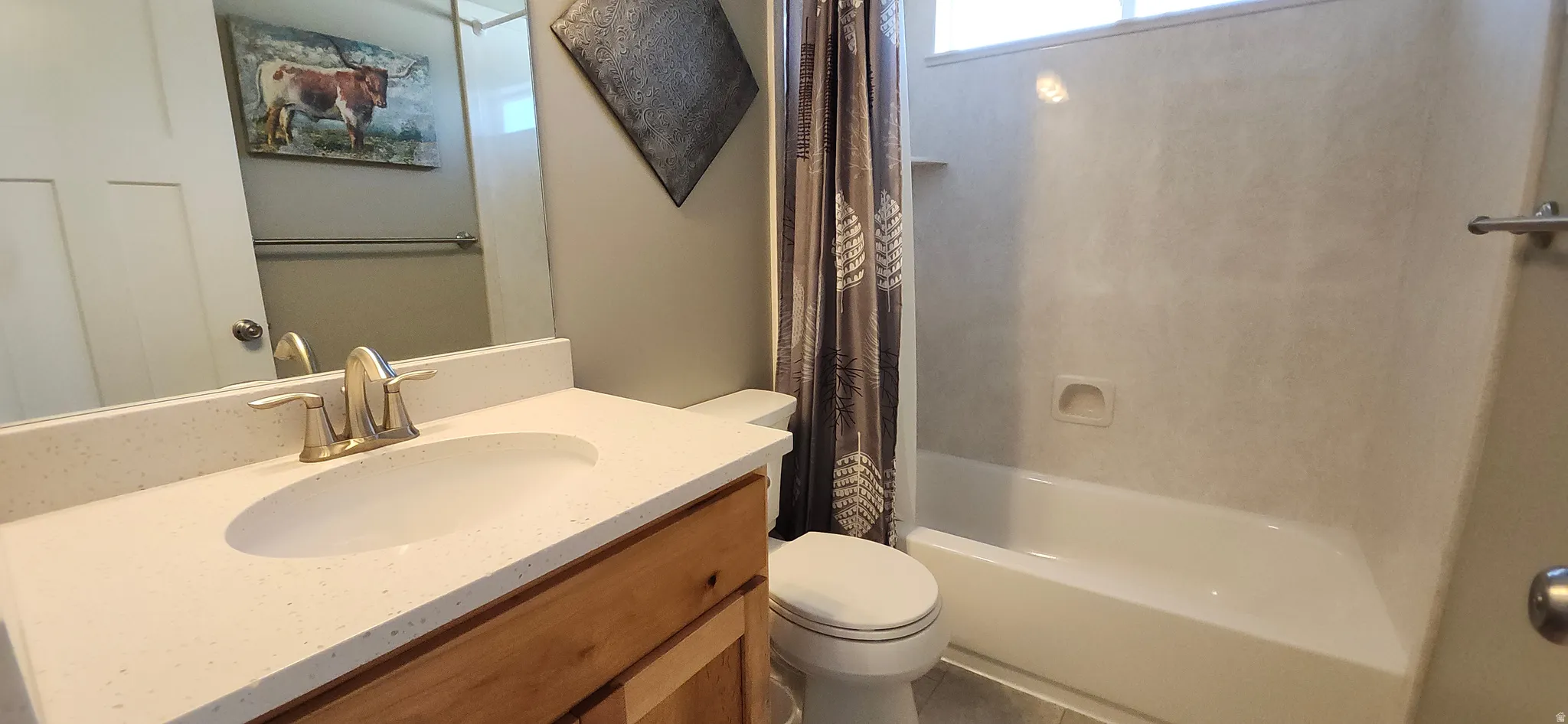Bathroom featuring vanity and shower / bathtub combination with curtain