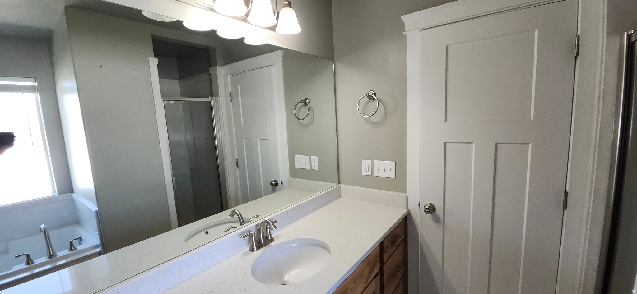 Full bath featuring vanity, healthy amount of natural light, a bath, and a stall shower