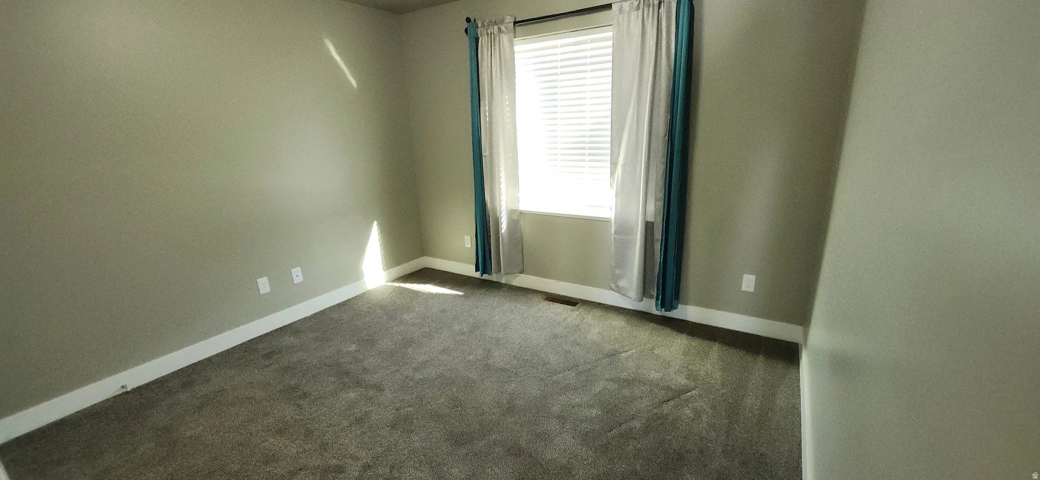Spare room featuring baseboards and carpet flooring