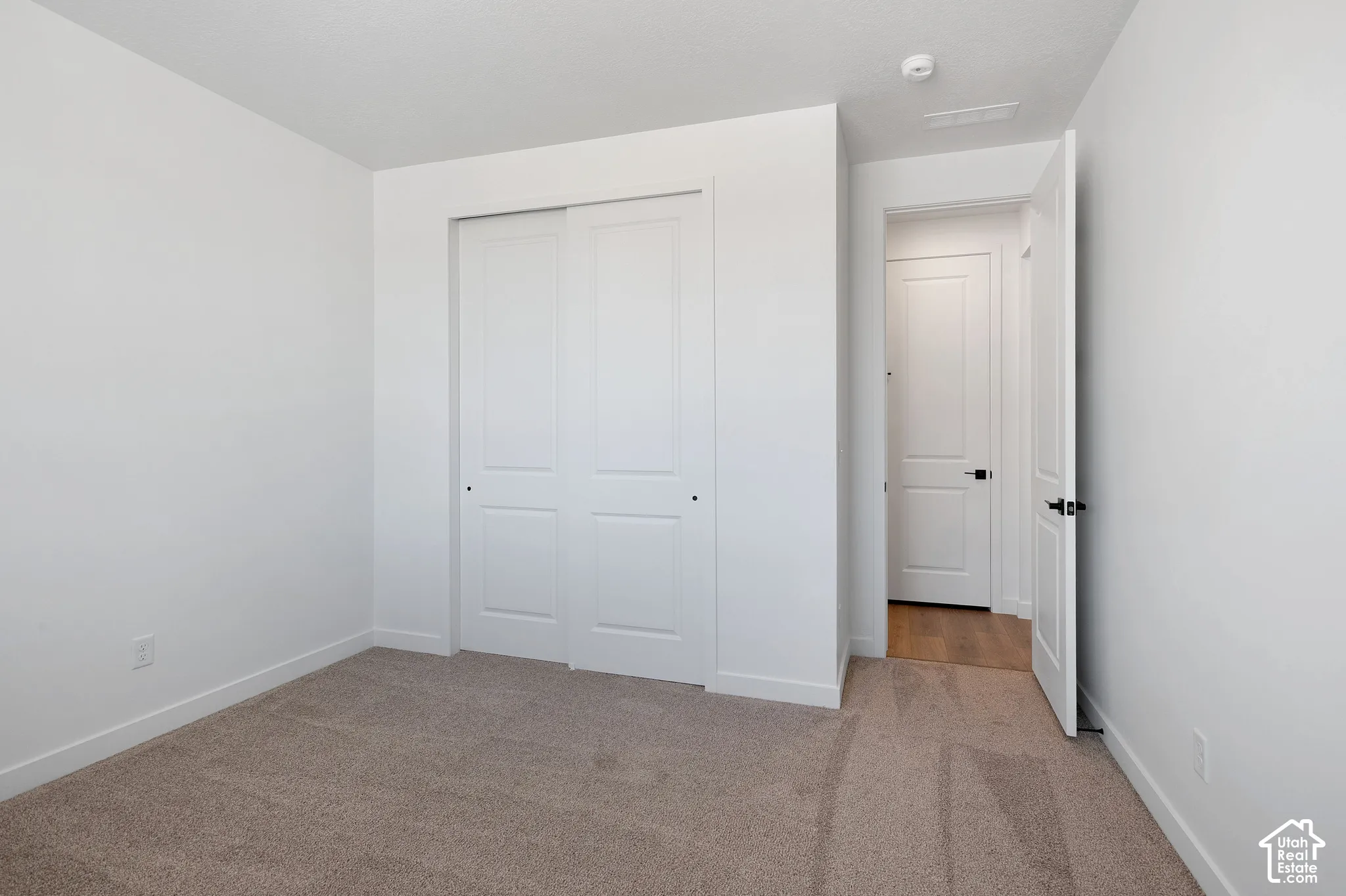 Neutral carpeting with white baseboards and walls