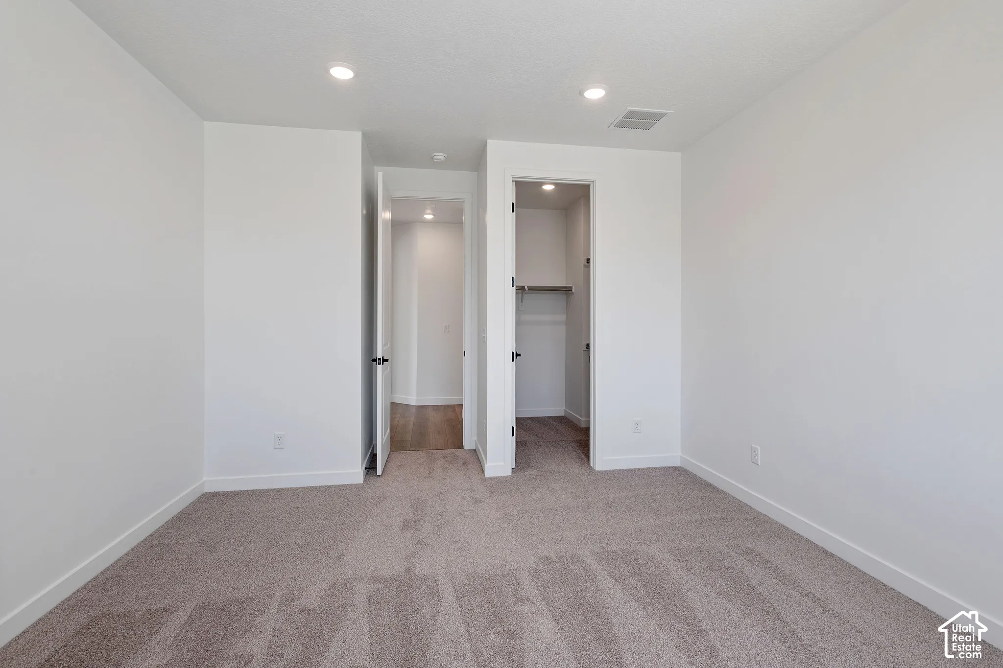 Plush carpet flooring, recessed ceiling lighting, and a built-in closet with shelving