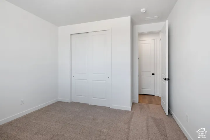 Neutral carpeting with white baseboards and walls