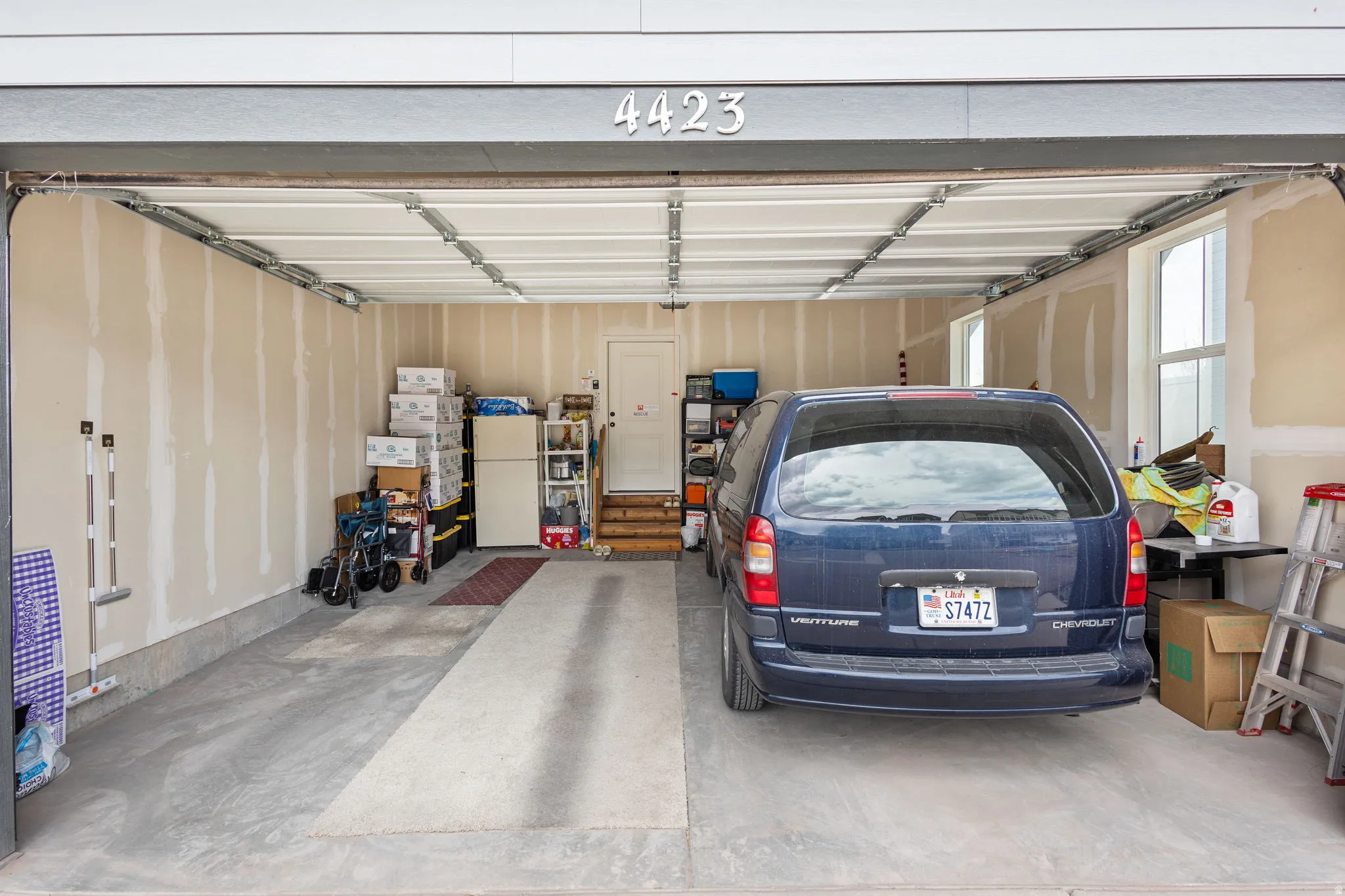 Concrete flooring garage with natural light windows and interior access door