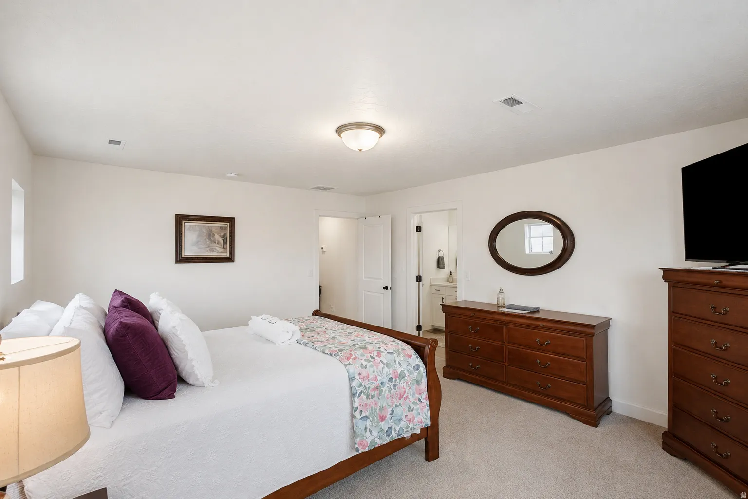 Carpeted room with white walls, a flush-mount ceiling light fixture, and a window providing natural light