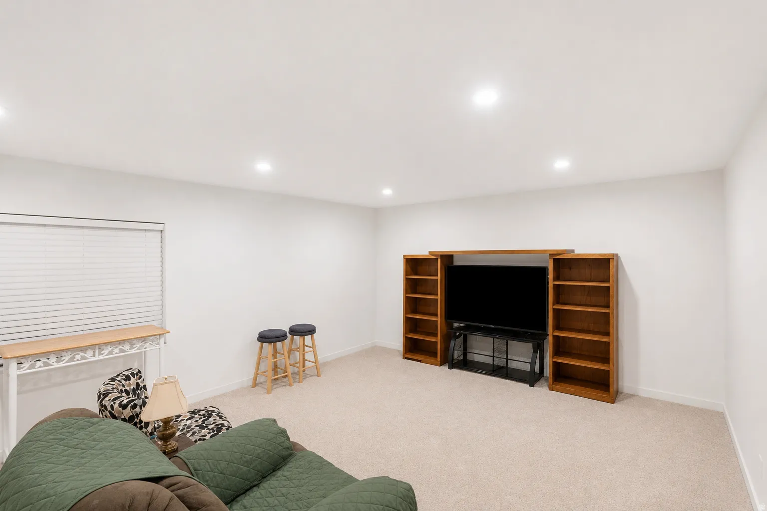 Spacious room with recessed lighting and neutral carpeting
