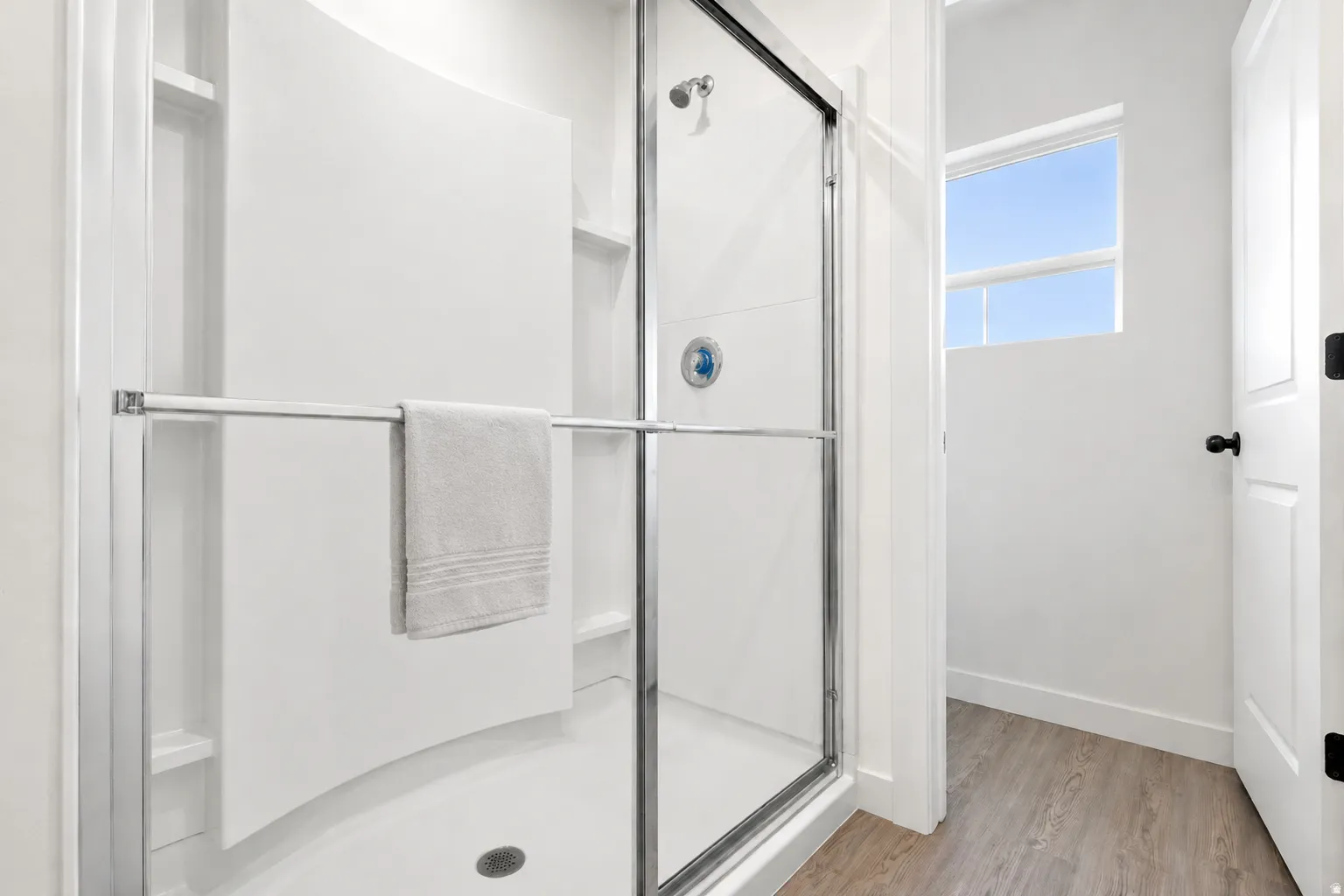 Walk-in shower with clear glass enclosure and chrome hardware