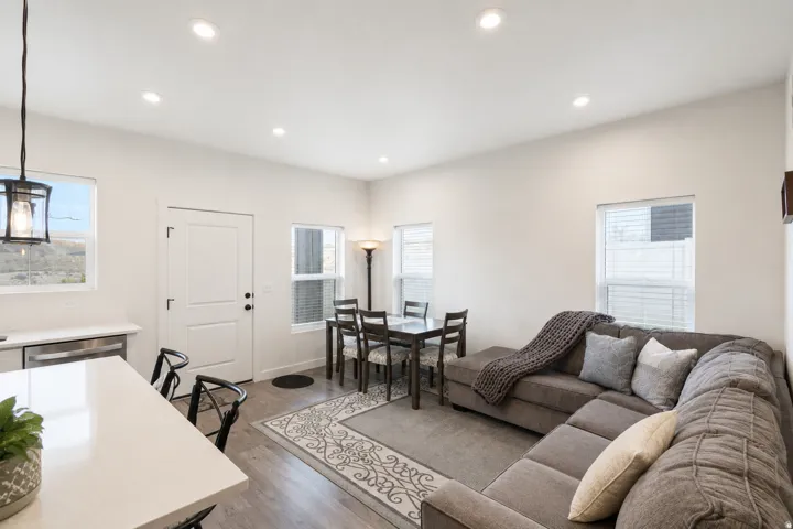 Open-concept living space featuring wood-finish flooring, recessed lighting, and multiple windows