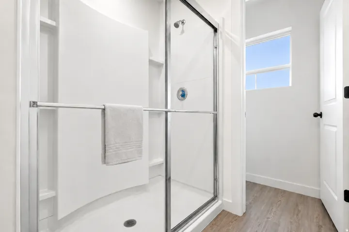 Walk-in shower with clear glass enclosure and chrome hardware