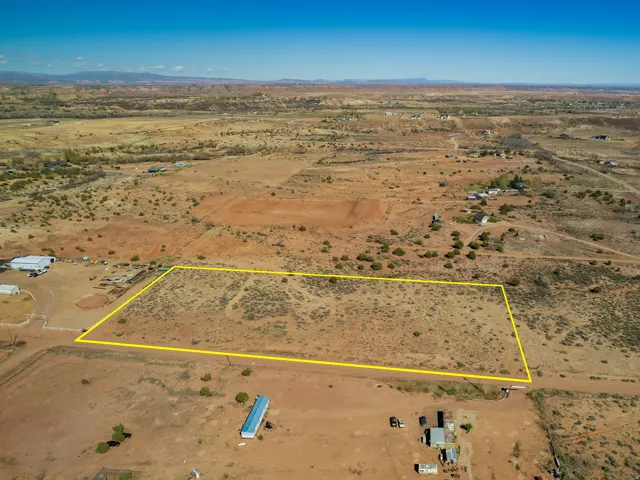 Aerial view of sparsely populated area with property parcel outlined and a mountain backdrop