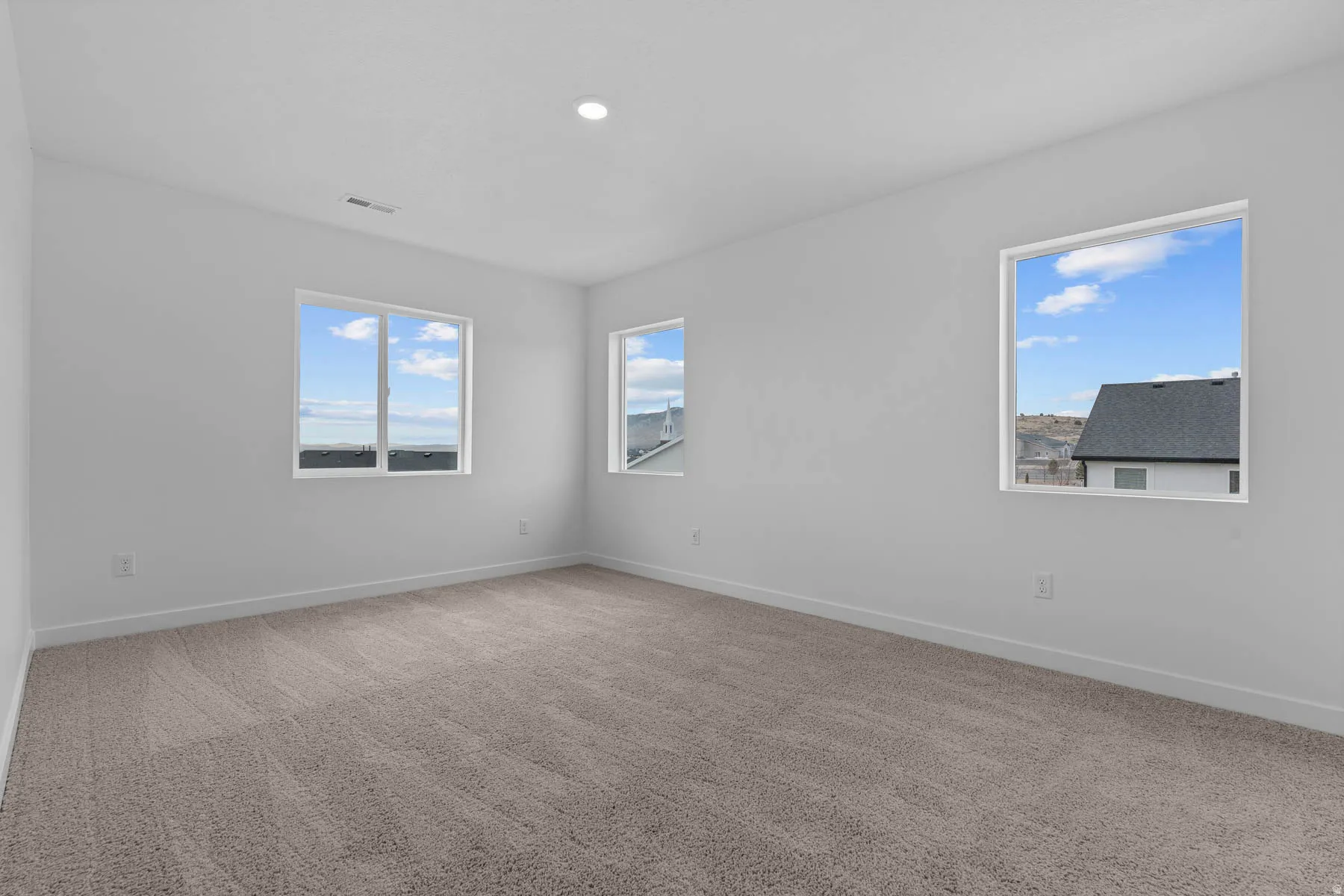 Spare room featuring light colored carpet and recessed lighting