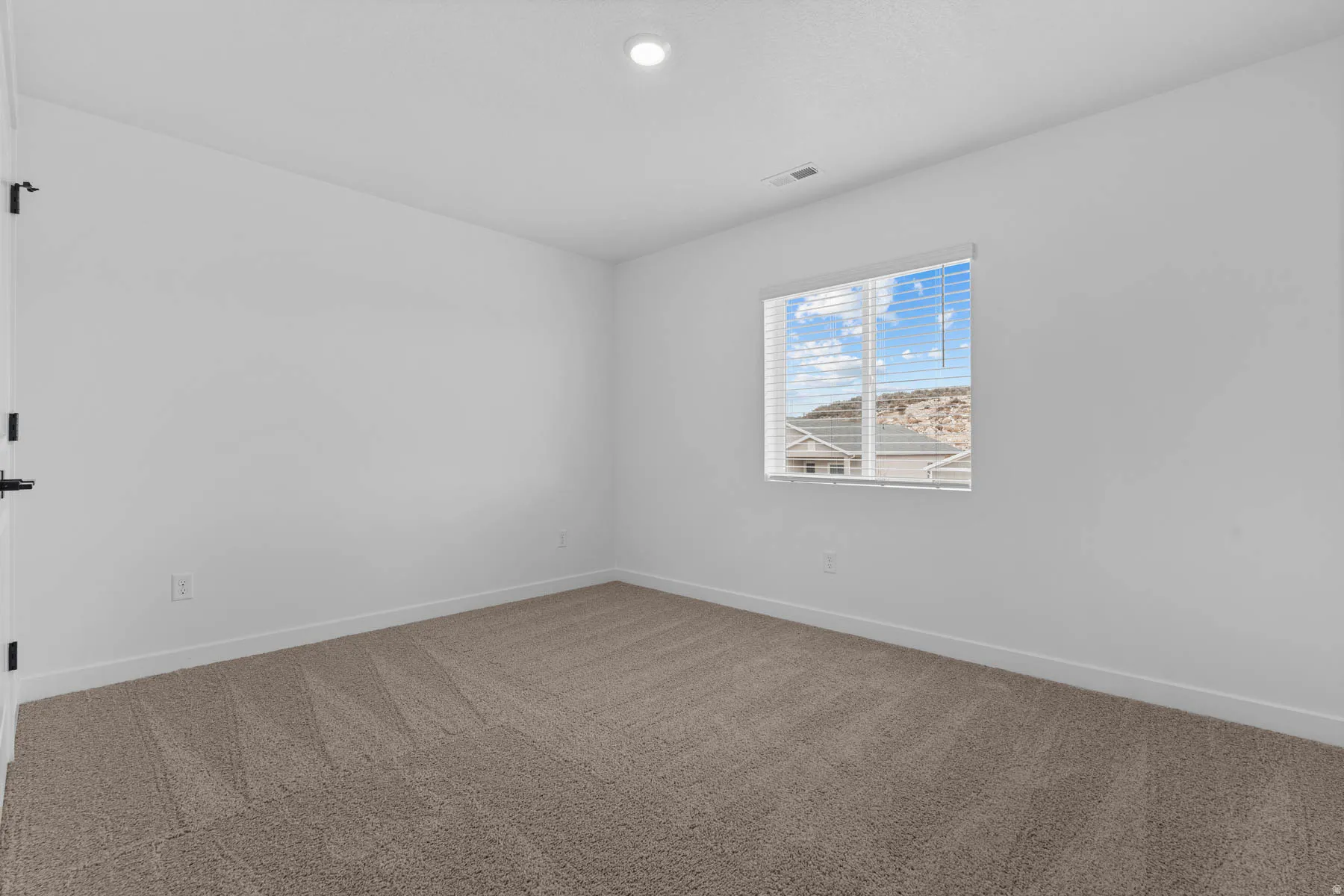 Carpeted empty room with baseboards