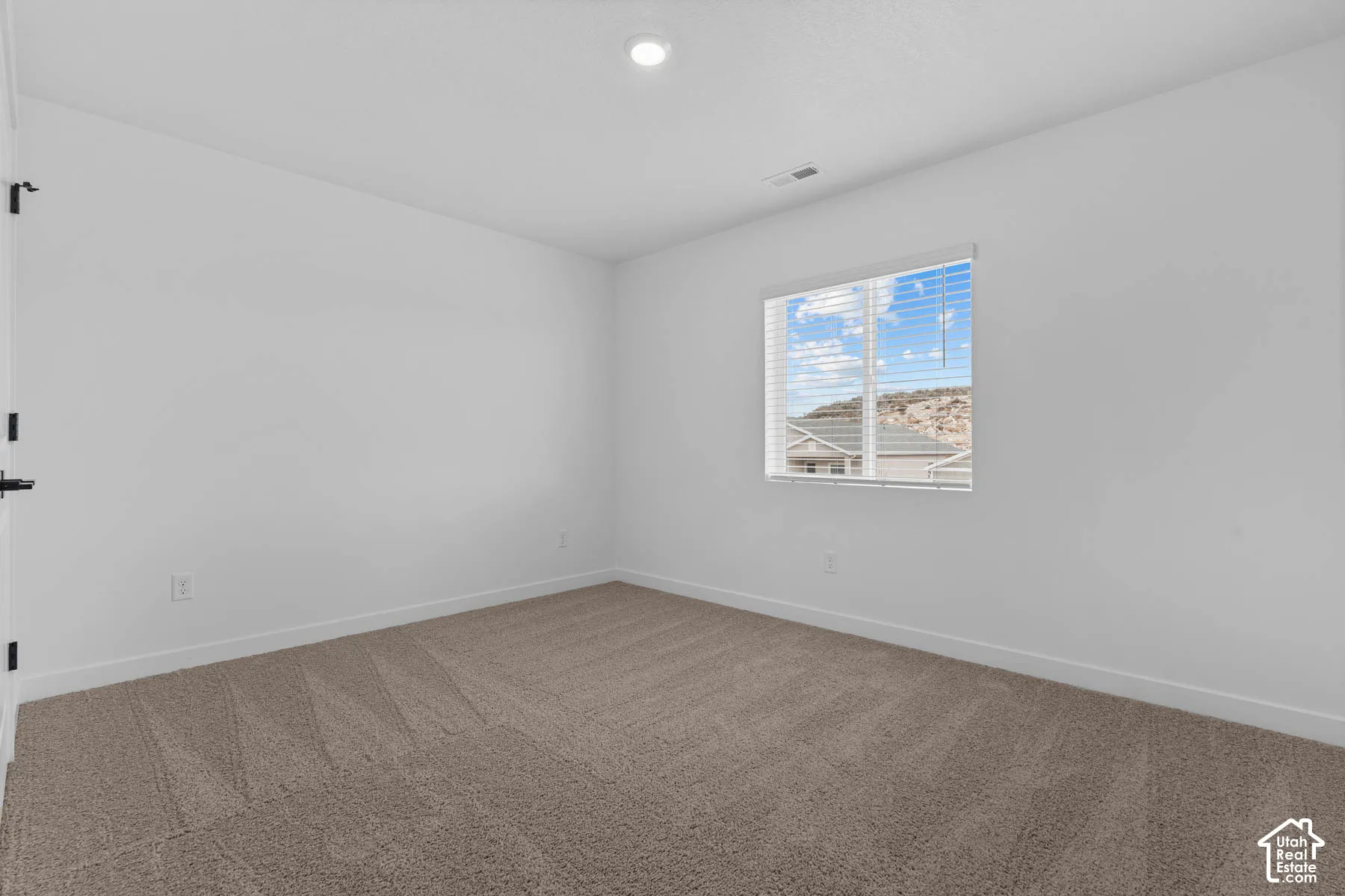 Carpeted empty room with baseboards