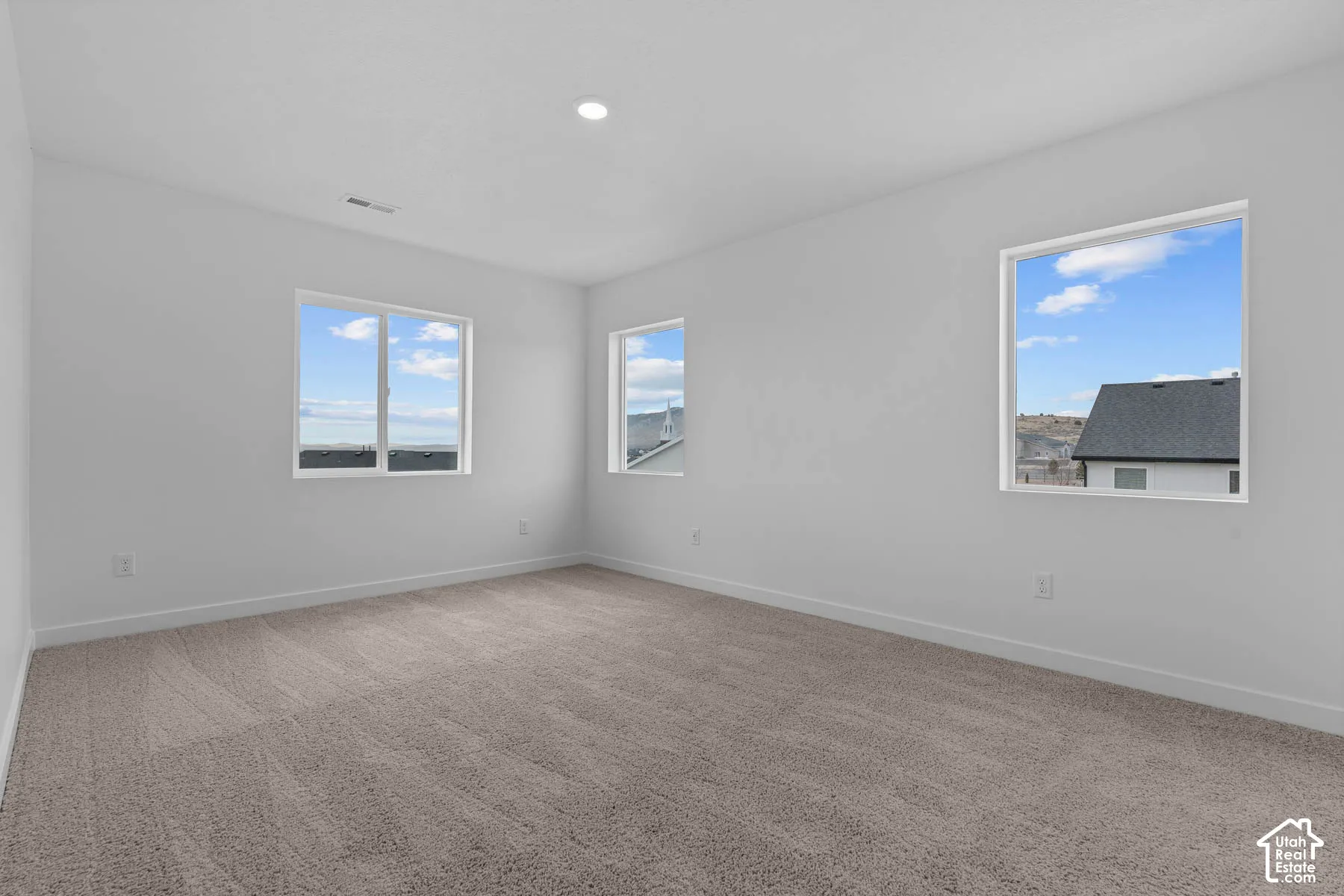 Spare room featuring light colored carpet and recessed lighting