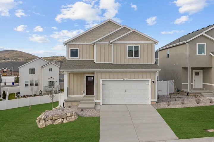 Craftsman inspired home featuring board and batten siding, an attached garage, concrete driveway, a mountain view, and a shingled roof