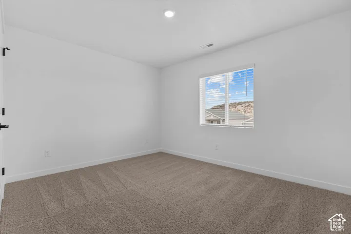 Carpeted empty room with baseboards