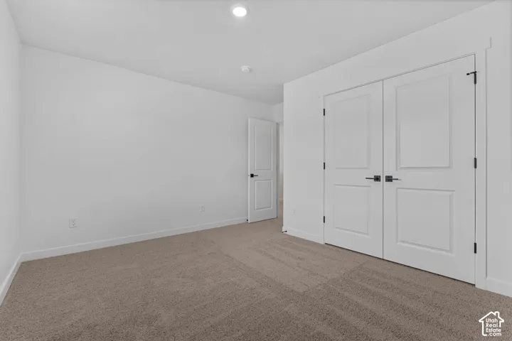 Unfurnished bedroom featuring carpet, a closet, and recessed lighting