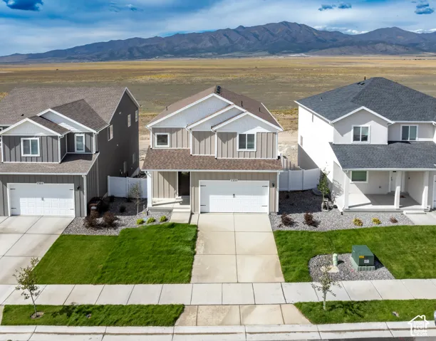 Two-story residence with a two-car garage, front yard landscaping, and mountain scenery