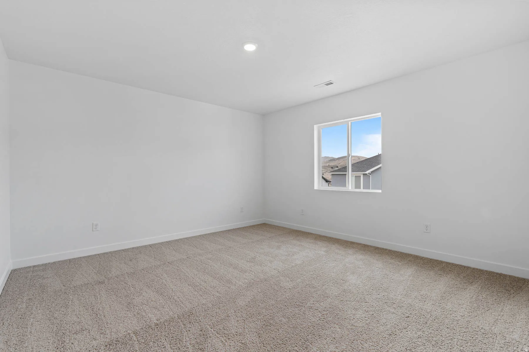 Unfurnished room featuring light carpet and baseboards