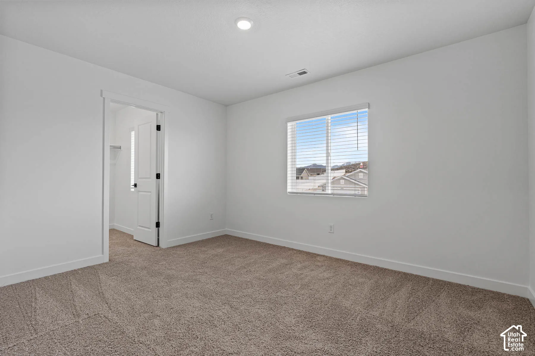 Carpeted spare room featuring baseboards