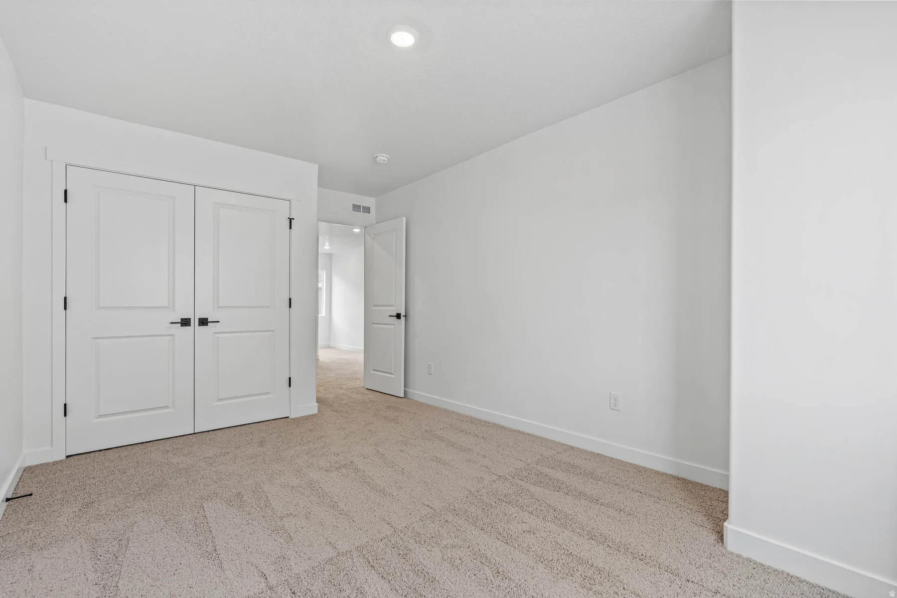Unfurnished bedroom featuring light colored carpet and a closet