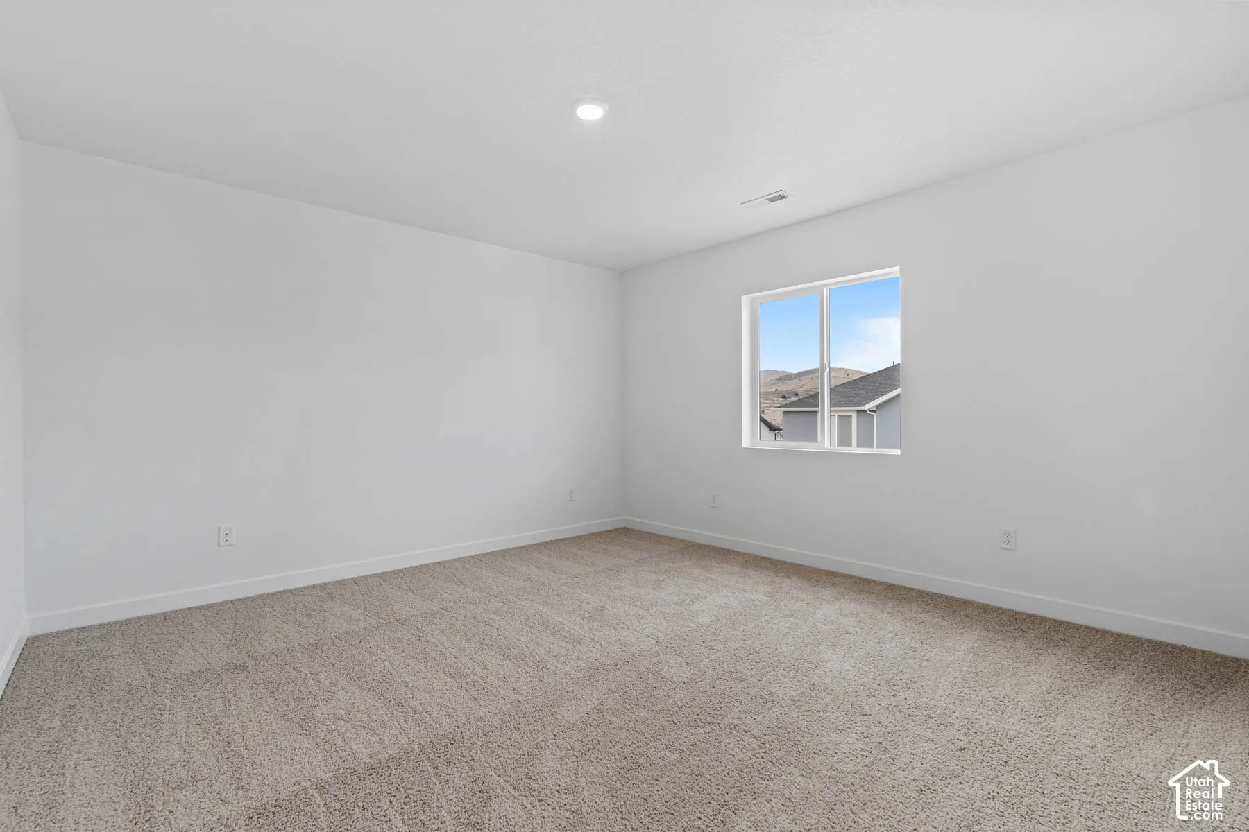 Unfurnished room featuring light carpet and baseboards