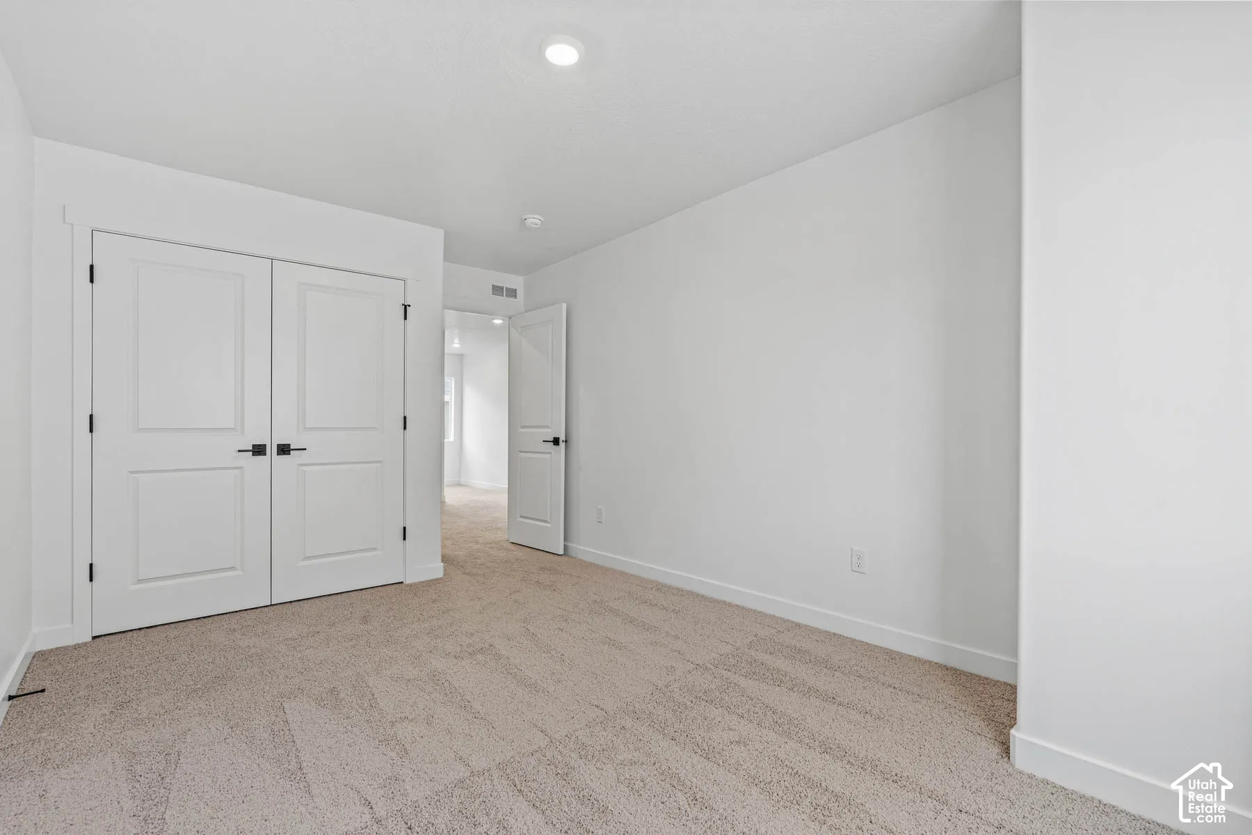 Unfurnished bedroom featuring light colored carpet and a closet