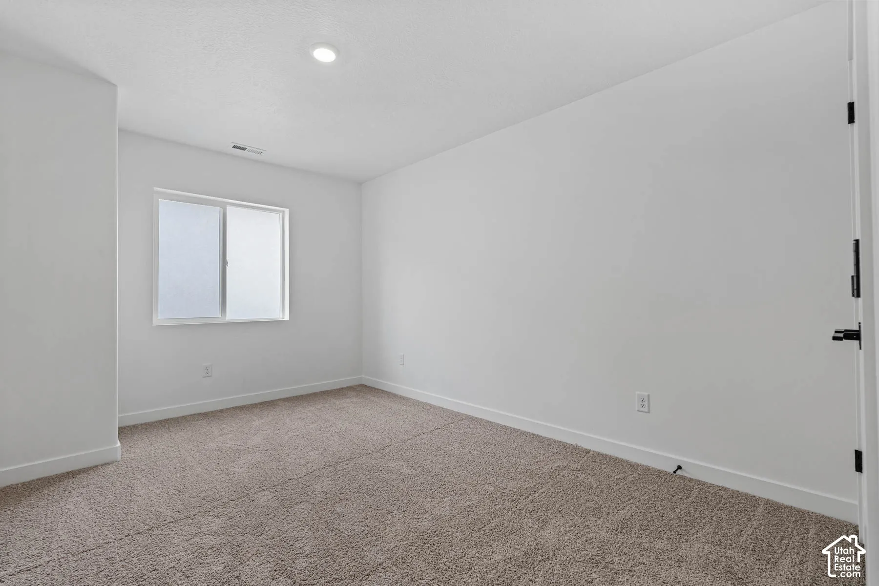 Carpeted empty room with baseboards