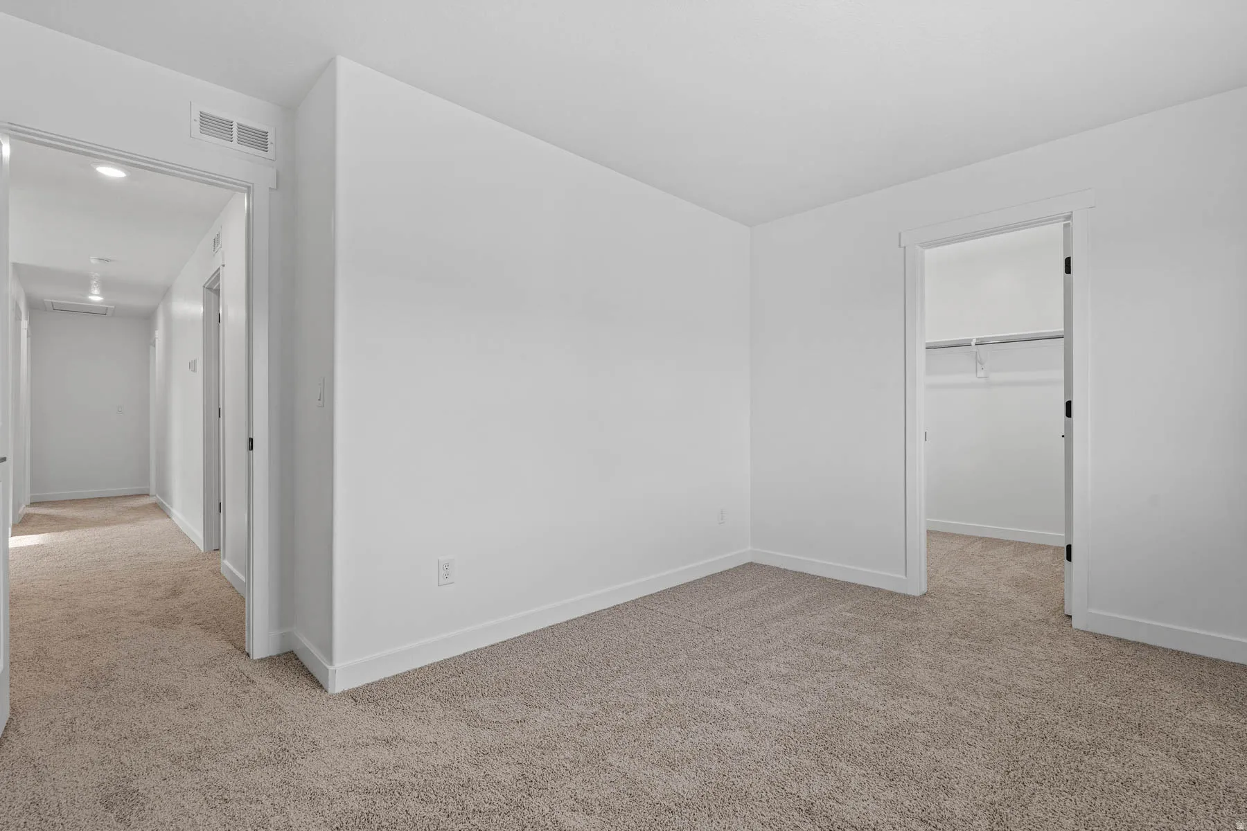 Unfurnished bedroom featuring a spacious closet, light colored carpet, and recessed lighting