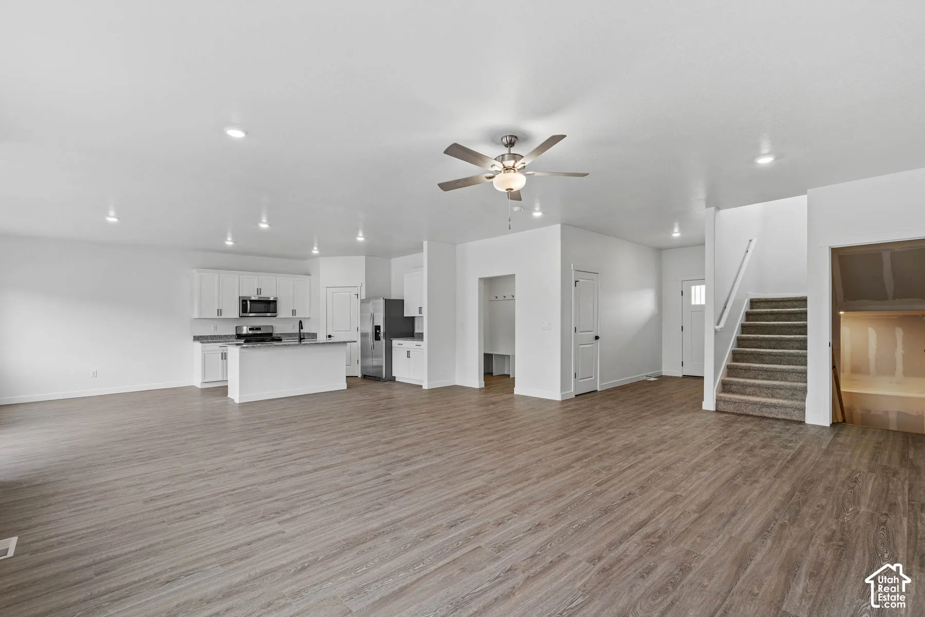 Unfurnished living room with ceiling fan, light wood-type flooring, and recessed lighting