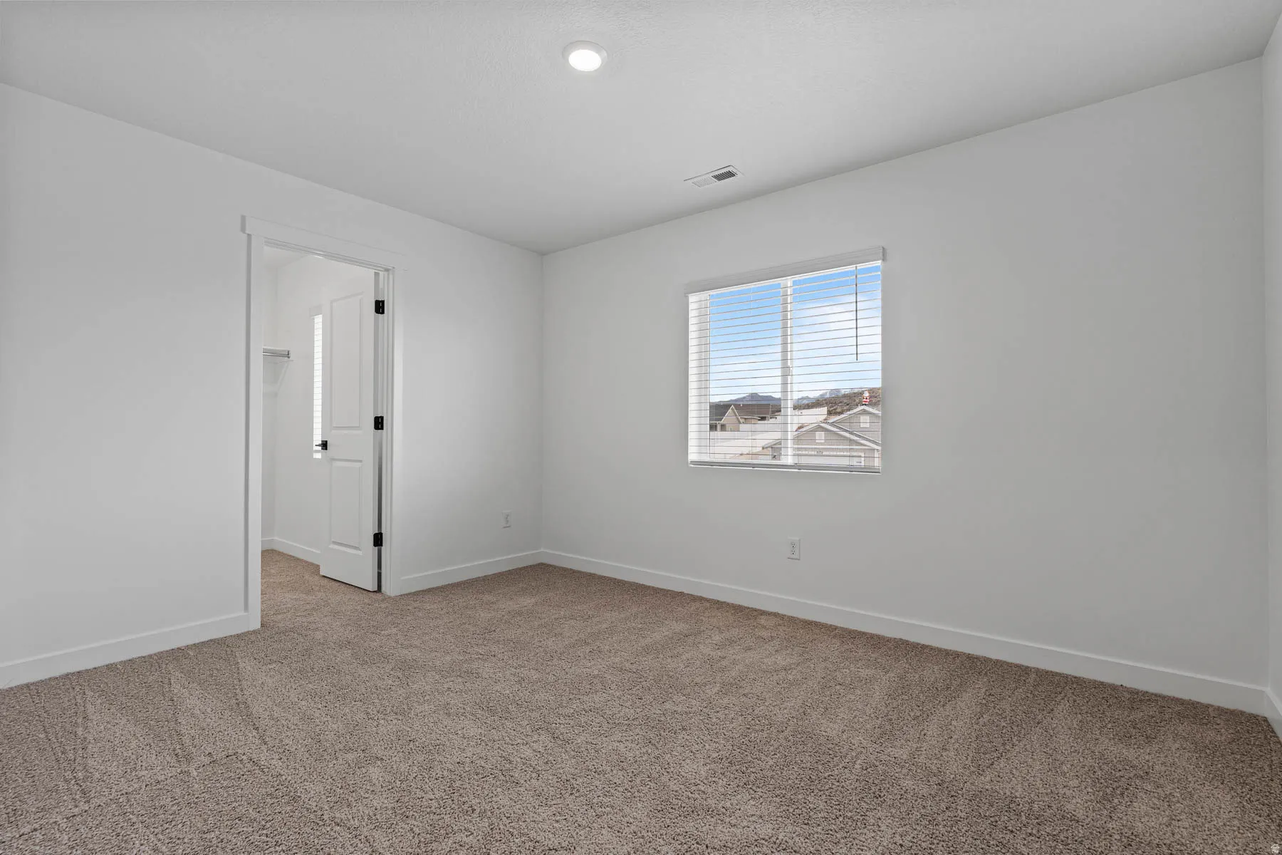 Carpeted spare room featuring baseboards