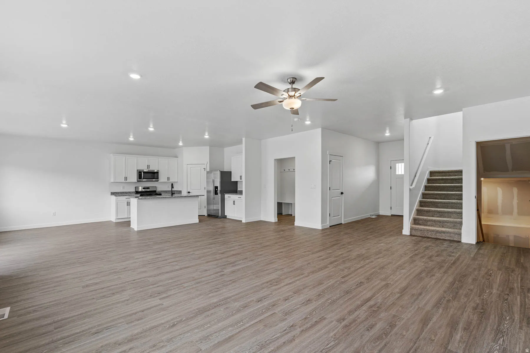 Unfurnished living room with ceiling fan, light wood-type flooring, and recessed lighting