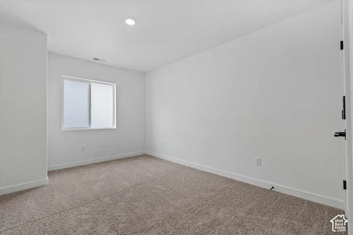 Carpeted empty room with baseboards