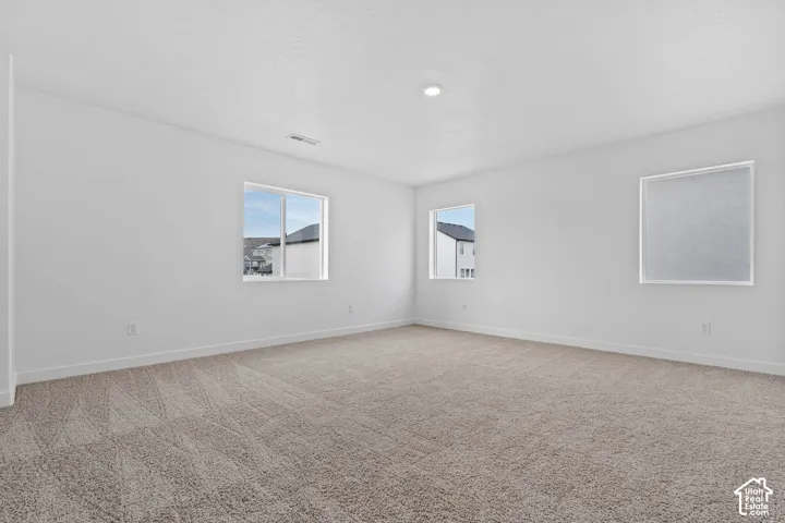 Unfurnished room with light colored carpet and baseboards