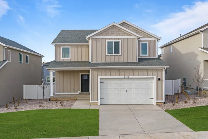 Craftsman-style house featuring a shingled roof, board and batten siding, an attached garage, covered porch, and concrete driveway