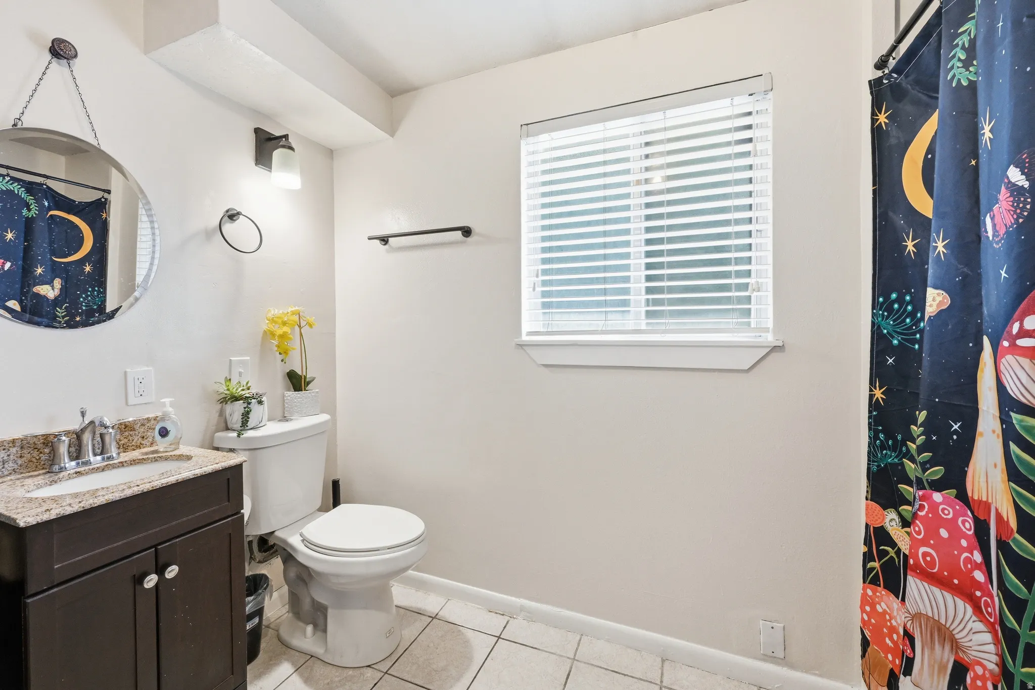 Full bathroom with a shower with shower curtain, vanity, and light tile patterned floors with laundry area