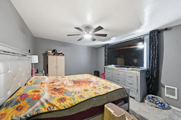 Bedroom #1 - Carpeted, featuring ceiling fan and heating unit