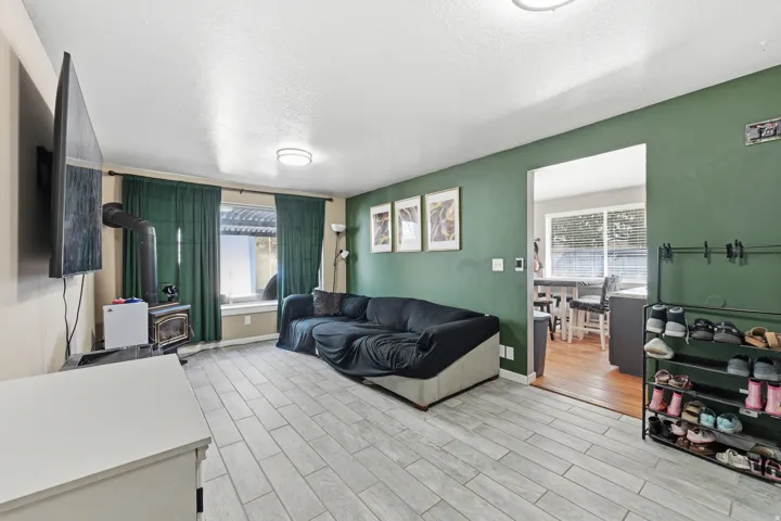 Living area with a gas stove, wood tiled floors, and a textured ceiling