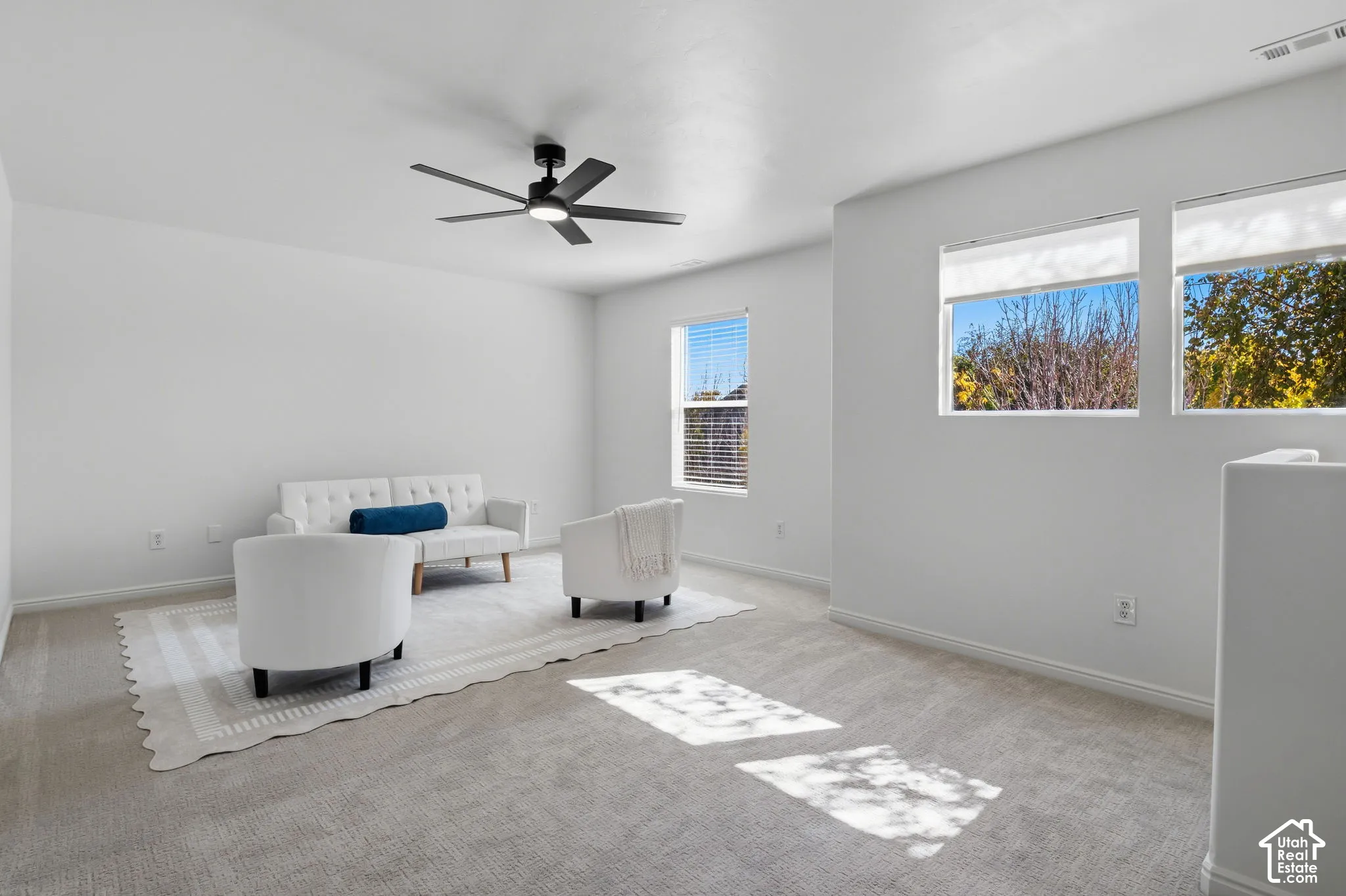 Recessed lighting, ceiling fan, multiple windows, light neutral carpet