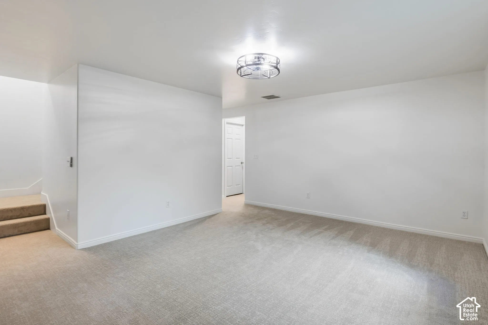 Recessed lighting, light gray carpeting, white painted walls, white trim, and a frosted glass ceiling light fixture