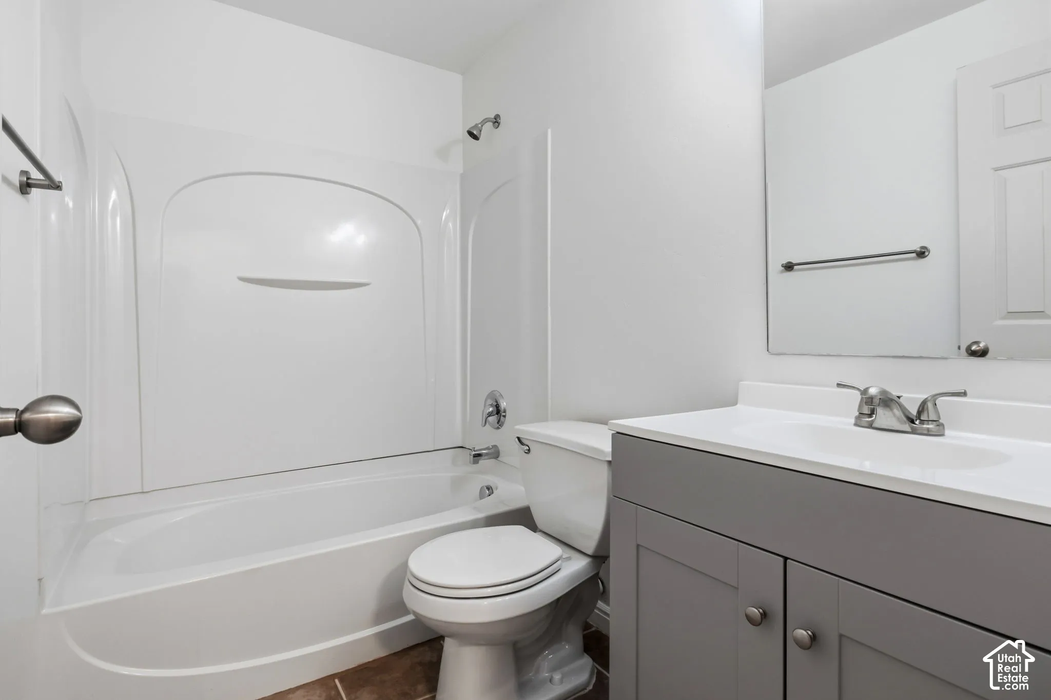 Bathroom featuring a white tub, shower with a curved wall surround, gray vanity with a white countertop, and a wall-mounted mirror