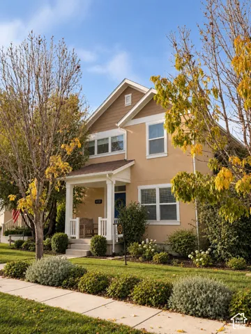 Two-story exterior featuring a gabled roofline, lap siding accents, and a covered front porch with white railing