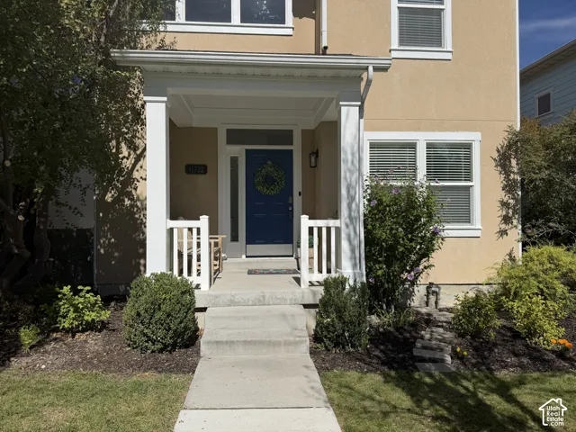 Stucco exterior with white trim windows and a covered porch